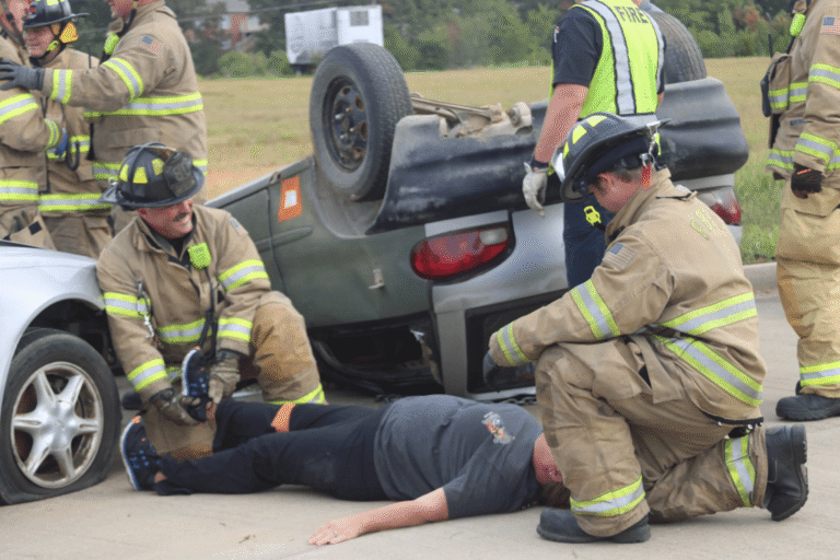 Firefighters assisting an injured person after a rollover accident.