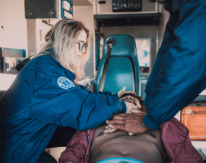 Paramedics performing CPR on an unresponsive man inside an ambulance during a medical emergency
